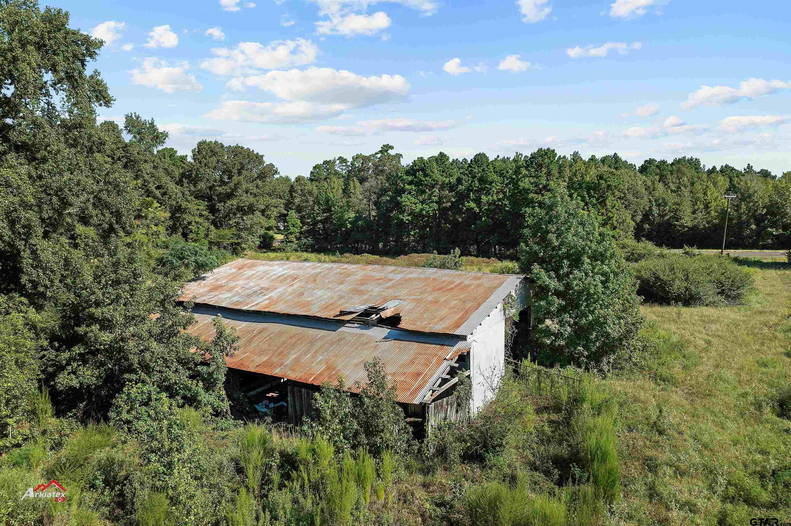 6973 FM 449 Marshall, TX 75670 - Photo 20 of 29 an aerial view of a house with yard and trees in the background