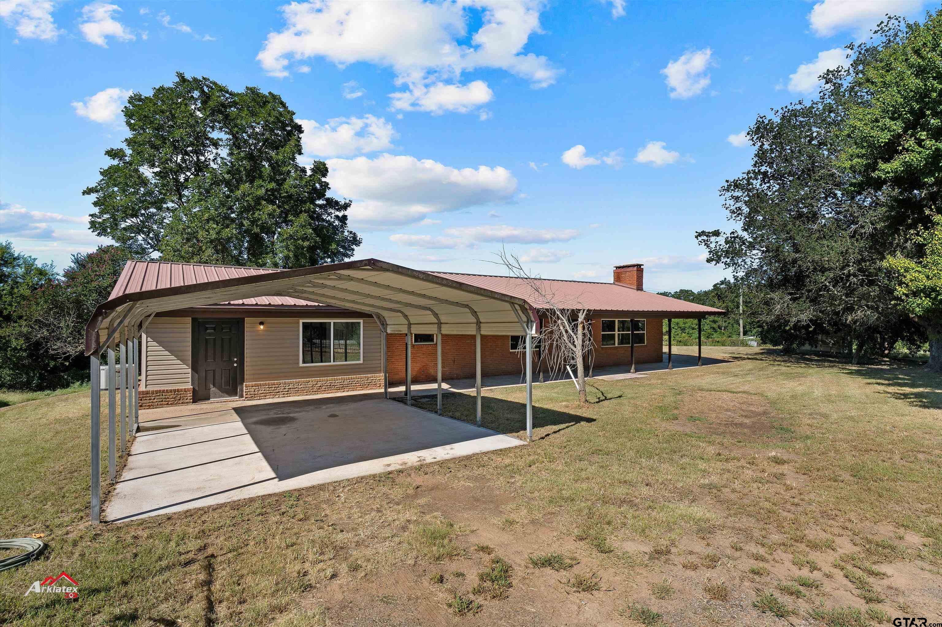 6973 FM 449 Marshall, TX 75670 - Photo 28 of 29 a front view of a house with a yard and garage