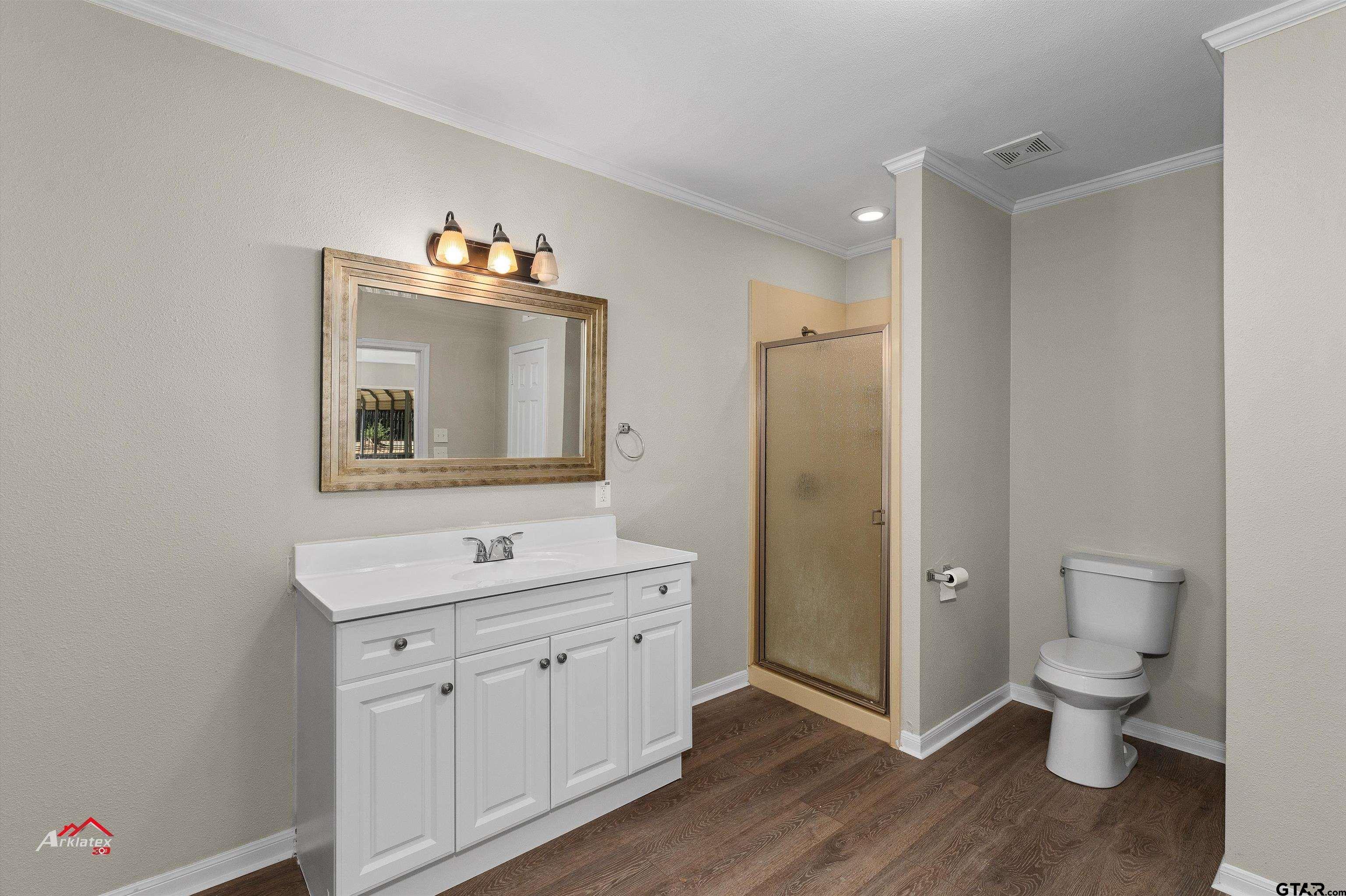 6973 FM 449 Marshall, TX 75670 - Photo 10 of 29 a spacious bathroom with a toilet sink and mirror