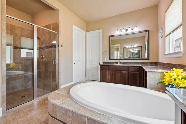 a bathroom with a tub sink and mirror