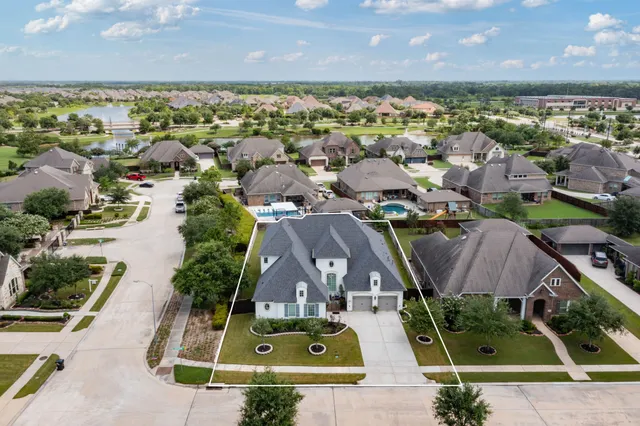 an aerial view of residential houses with outdoor space and swimming pool