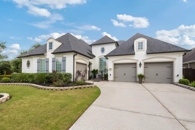 a front view of a house with a yard and potted plants
