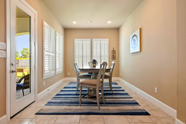 a dining room with wooden floor and a floor to ceiling window