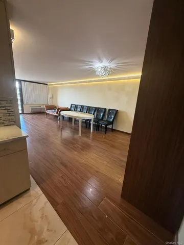 a view of a livingroom with wooden floor and a dining table