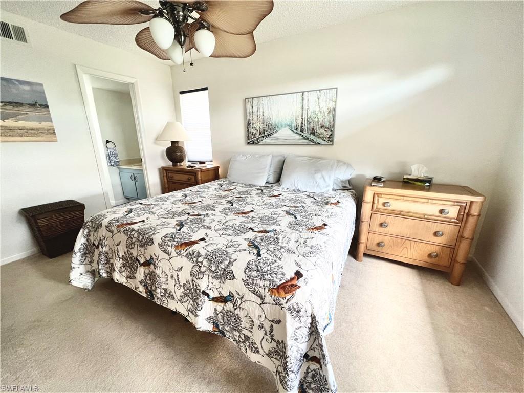 4338 27th Court Southwest, Unit 8201 Naples, FL 34116 - Photo 4 of 16 a bed sitting in a bedroom next to a lamp