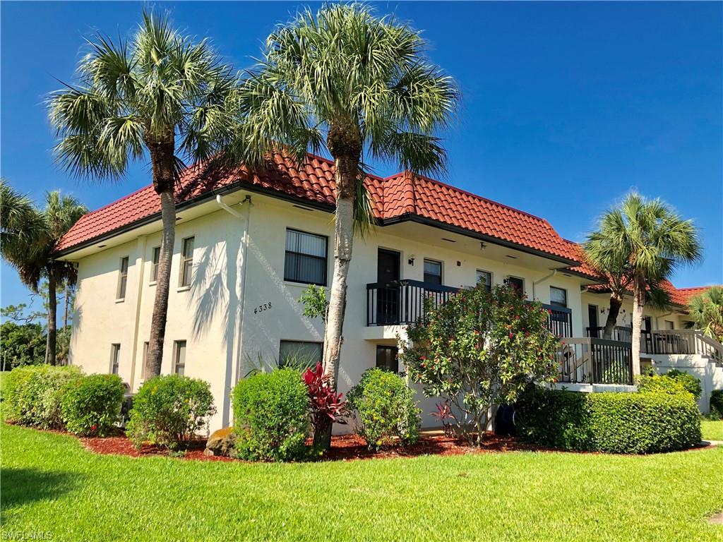 4338 27th Court Southwest, Unit 8201 Naples, FL 34116 - Photo 10 of 16 a front view of a house with a yard