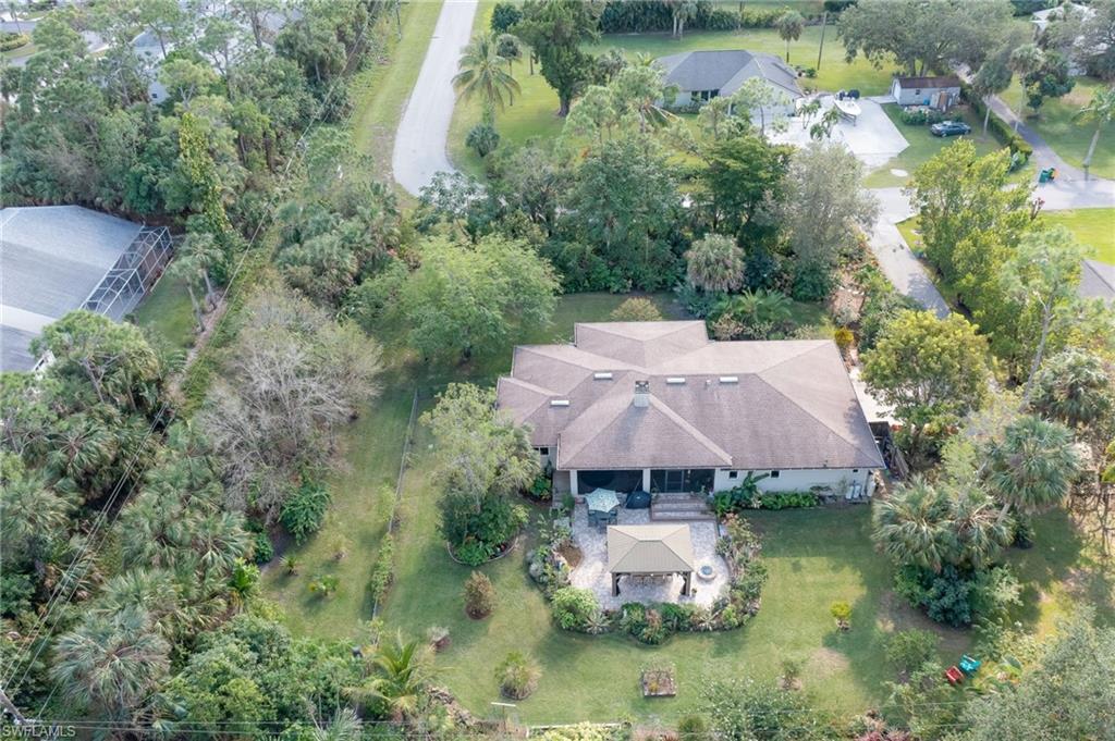 an aerial view of a house with swimming pool and outdoor seating