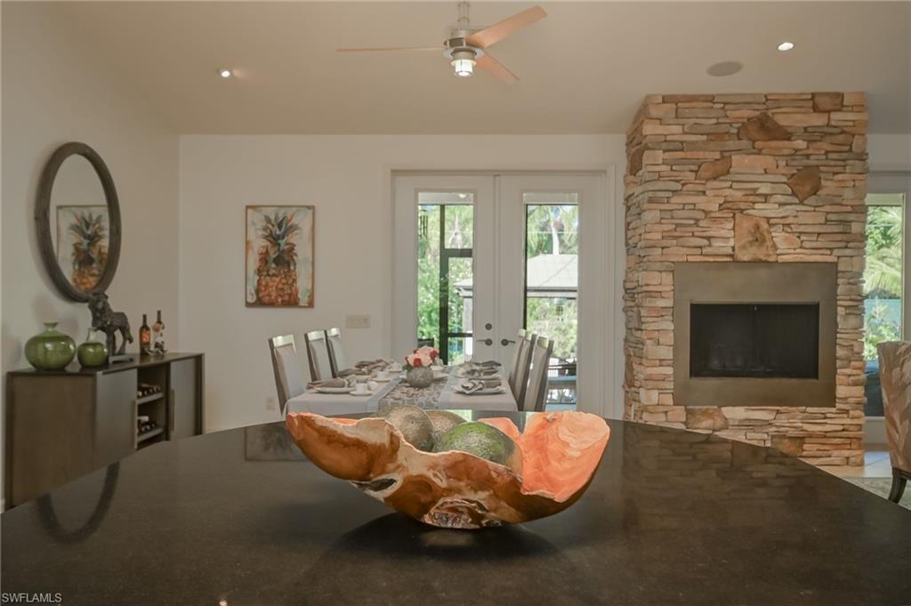 6350 Parkers Hammock Road Naples, FL 34112 - Photo 13 of 49 a living room with furniture a table and a fireplace