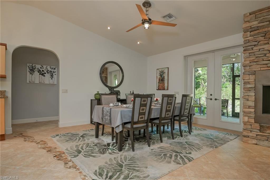 6350 Parkers Hammock Road Naples, FL 34112 - Photo 14 of 49 a view of a dining room and livingroom with furniture wooden floor a rug a painting and a chandelier