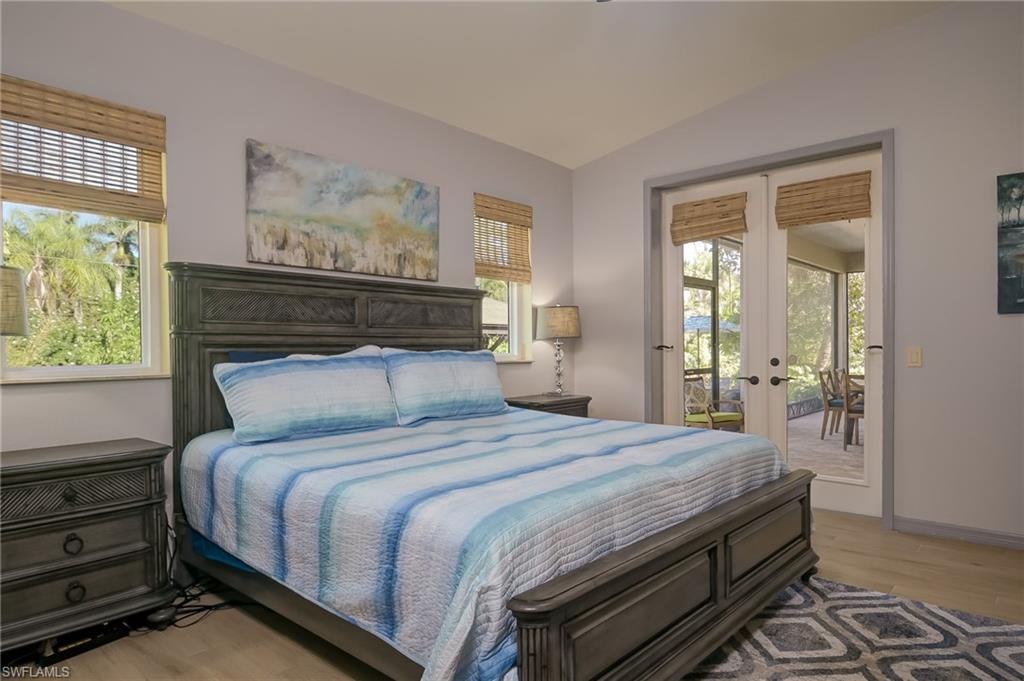 6350 Parkers Hammock Road Naples, FL 34112 - Photo 17 of 49 a bedroom with a bed and wooden floor