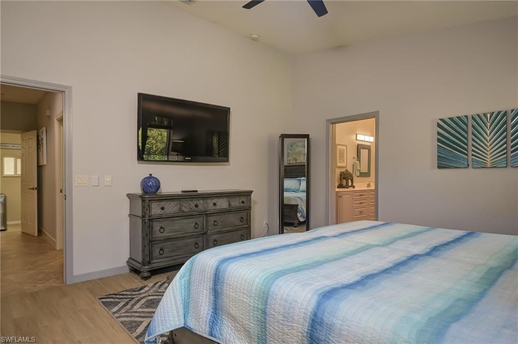 6350 Parkers Hammock Road Naples, FL 34112 - Photo 18 of 49 a bedroom with a bed and a flat screen tv