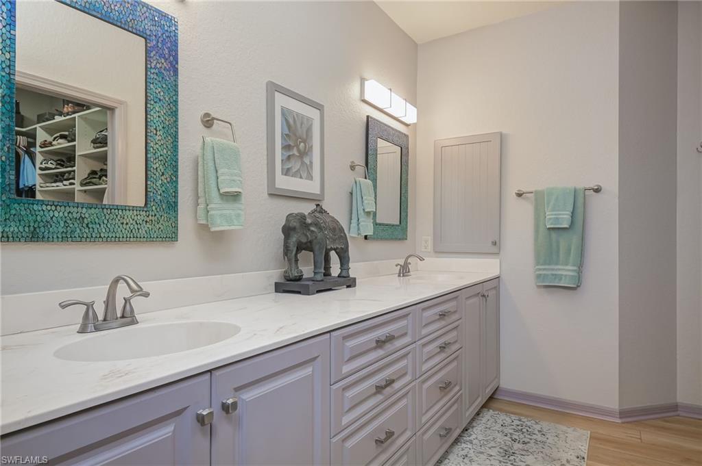 6350 Parkers Hammock Road Naples, FL 34112 - Photo 19 of 49 a bathroom with double sink and a mirror