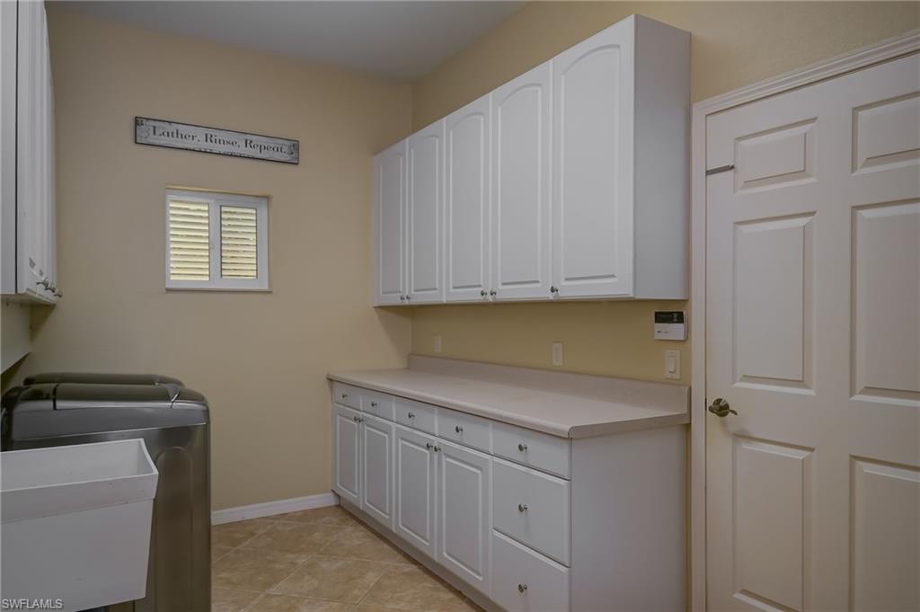 6350 Parkers Hammock Road Naples, FL 34112 - Photo 24 of 49 a utility room with cabinets washer and dryer