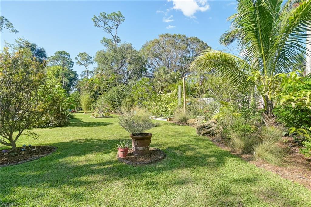6350 Parkers Hammock Road Naples, FL 34112 - Photo 31 of 49 a view of a garden with a bench