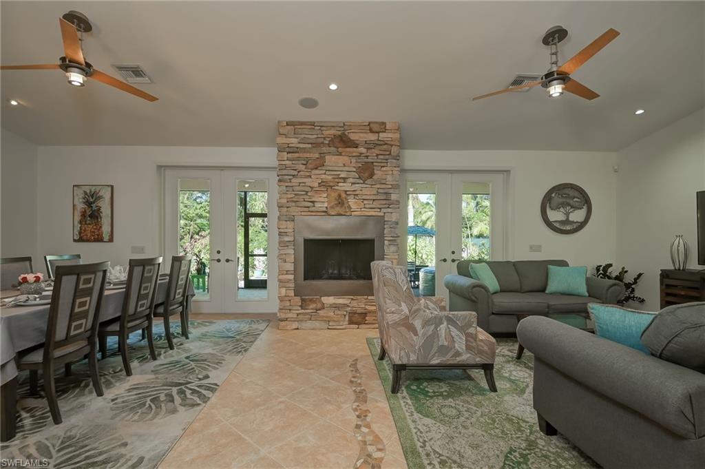 6350 Parkers Hammock Road Naples, FL 34112 - Photo 6 of 49 a living room with furniture a fireplace and a ceiling fan