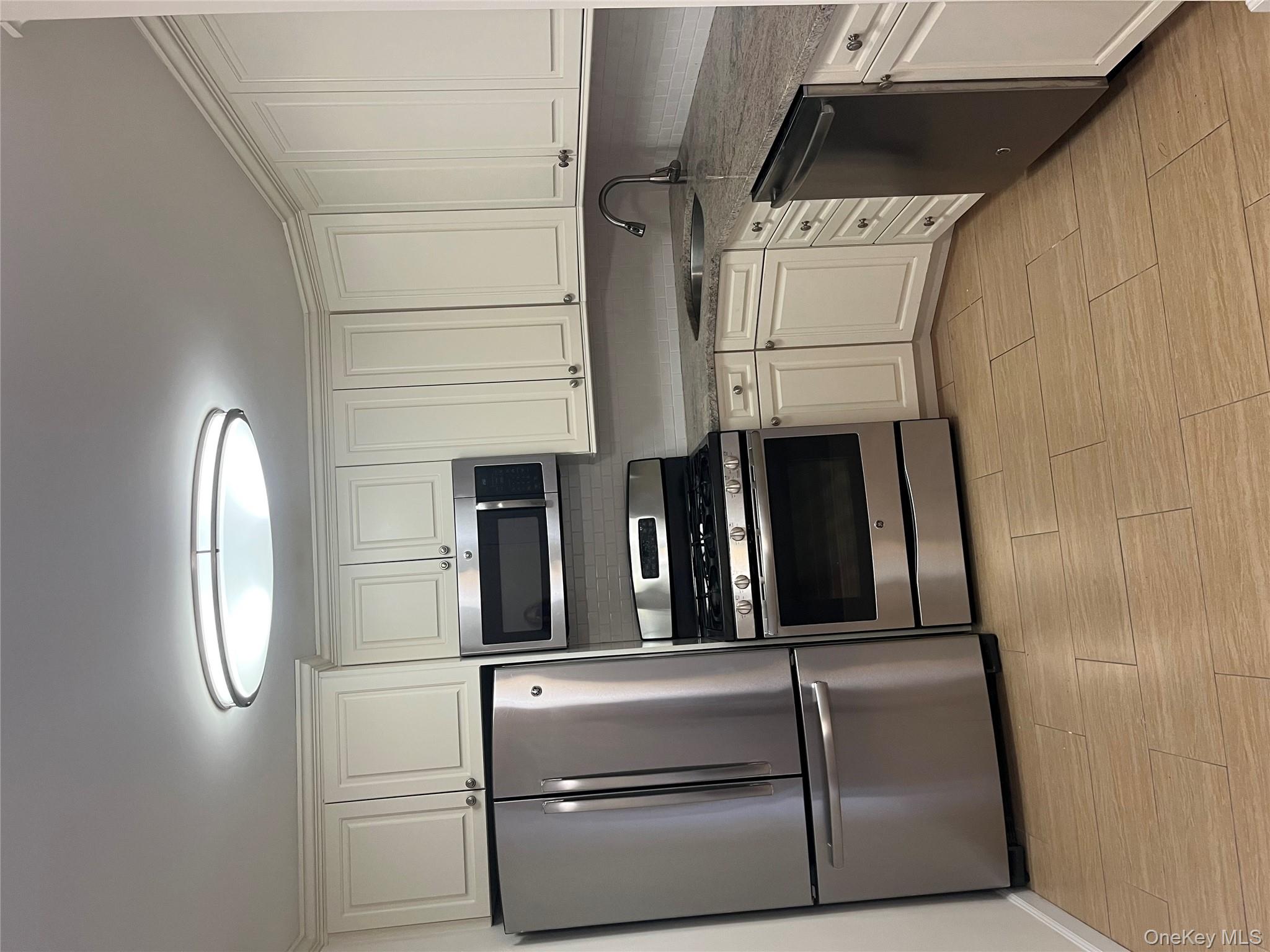 2 Bay Club Drive, Unit 6D Queens, NY 11360 - Photo 2 of 17 a kitchen with granite countertop a refrigerator and a stove top oven