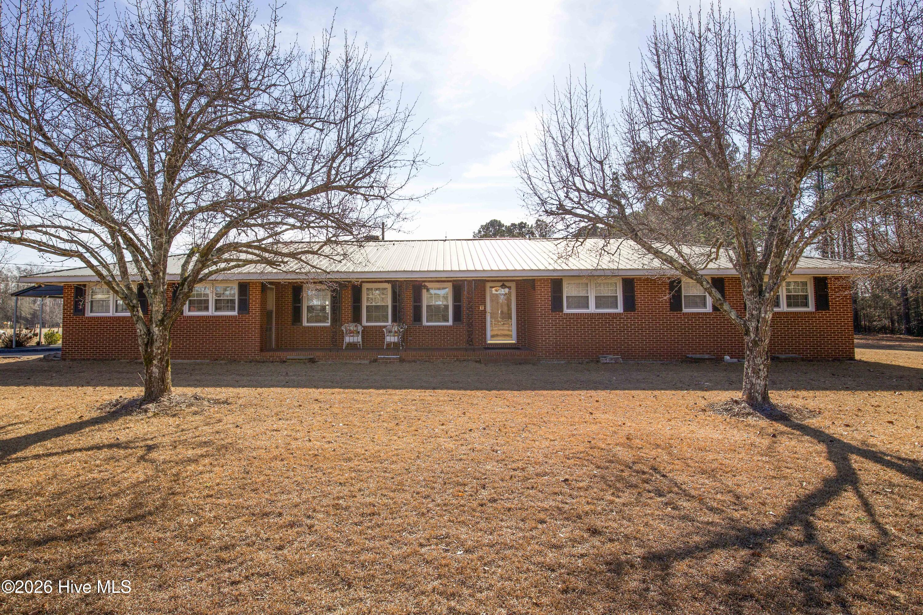 Welcome home to this timeless all-brick ranch on over an acre in Moore County—outside city limits, with no HOA! This 1967-built home features strong curb appeal, highlighted by a covered front porch and a durable metal roof. The front yard is framed by two mature Bradford pear trees that come alive in the spring with beautiful white blossoms, adding vibrant color and charm. The home’s classic layout and sturdy construction reflect a style and quality rarely found today. Conveniently located with multiple routes for easy access to Fort Bragg, this property blends peaceful country living with commuter-friendly convenience.