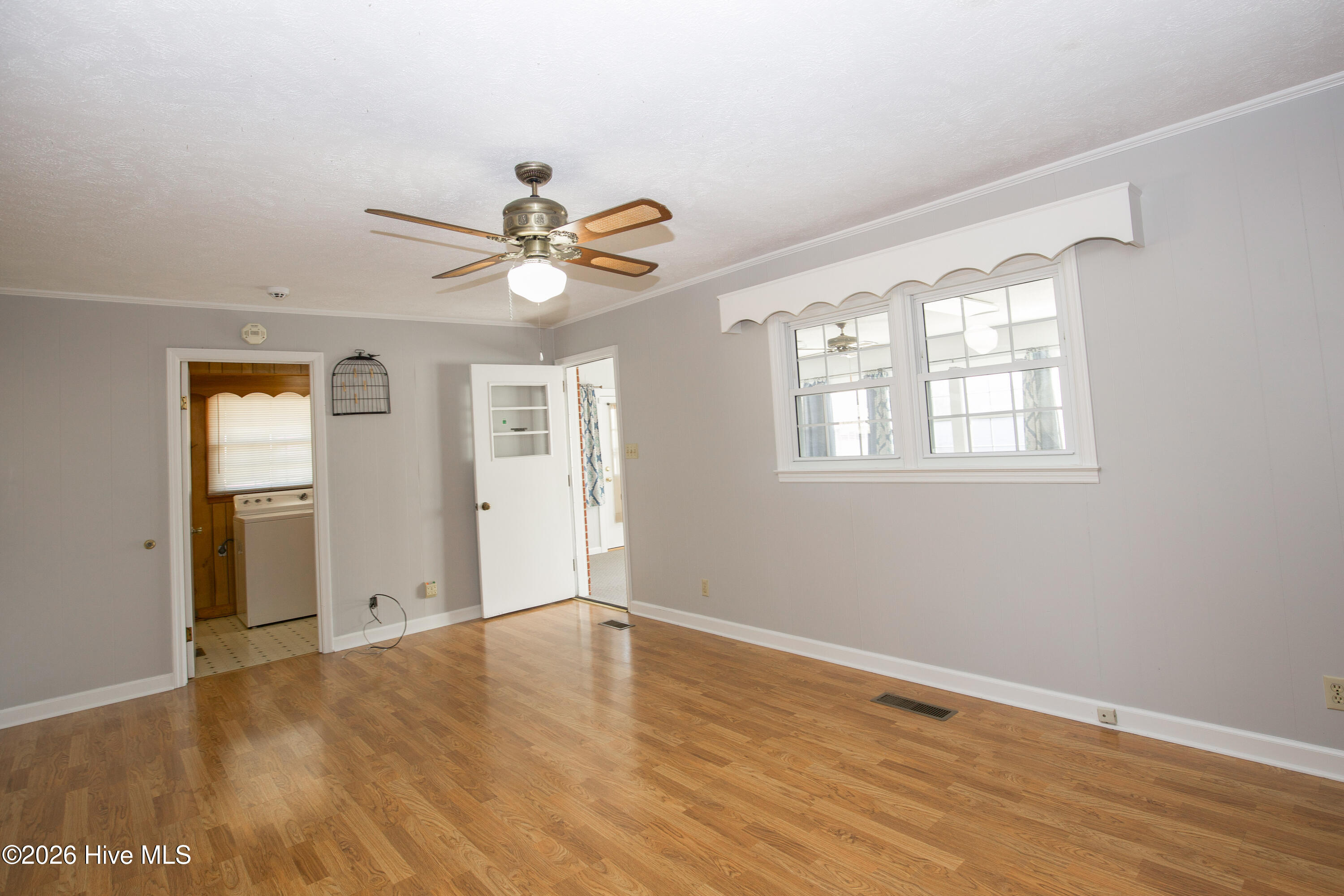 5068 Lobelia Road Vass, NC 28394 - Photo 29 of 70 This view from the family room showcases access to the laundry room on the left and the bright Carolina Room on the right. The wall of windows brings in extra natural light while offering a peek into the sunny bonus space. With access to key functional areas of the home, this room anchors the layout with both comfort and convenience.