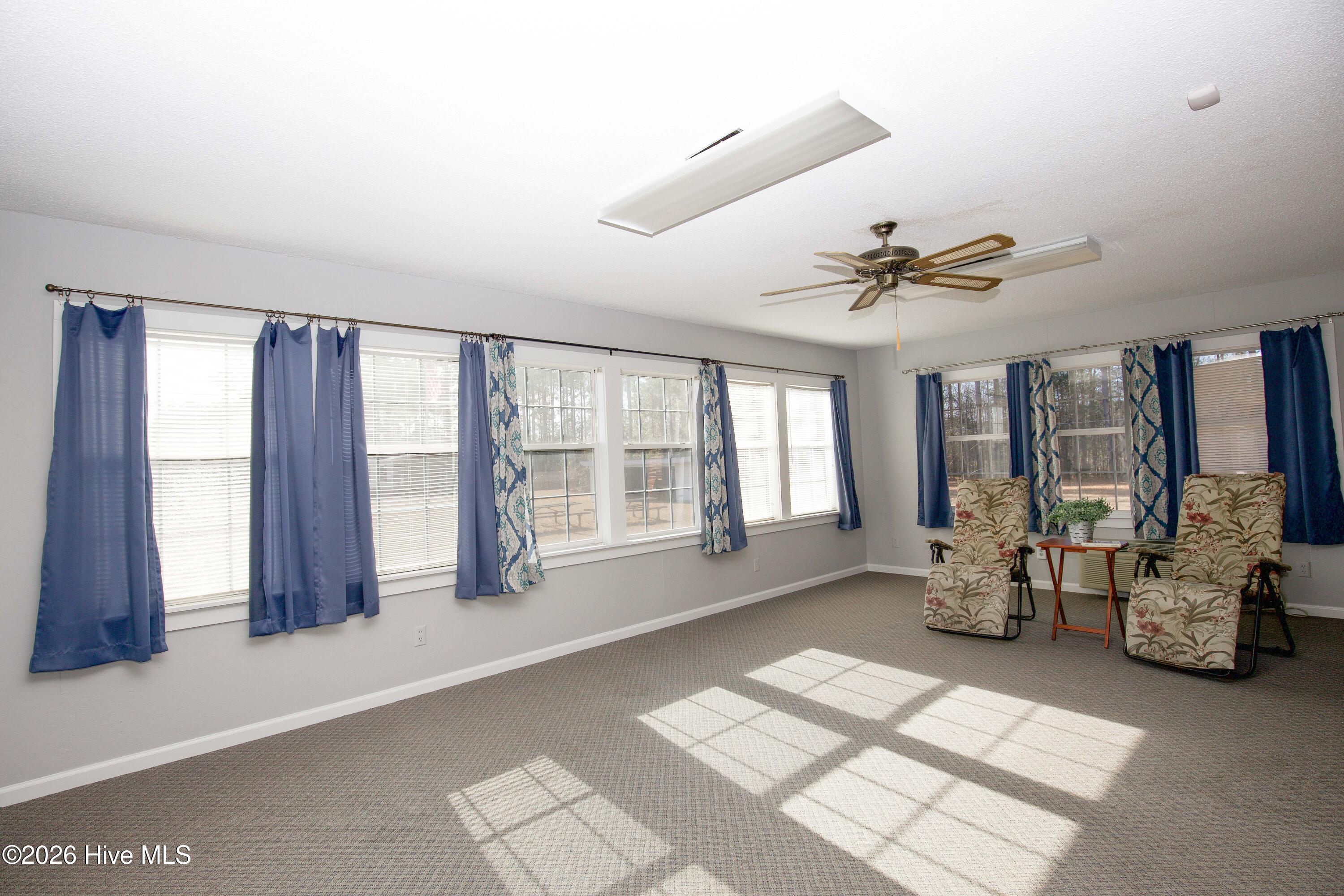 5068 Lobelia Road Vass, NC 28394 - Photo 34 of 70 Enjoy panoramic views and an abundance of natural light in the Carolina Room, surrounded by windows that invite the outdoors in. This bright and airy space is perfect for relaxing, entertaining, or using as a flexible bonus room. Neutral tones and soft carpeting create a cozy feel while allowing you to make the room your own.