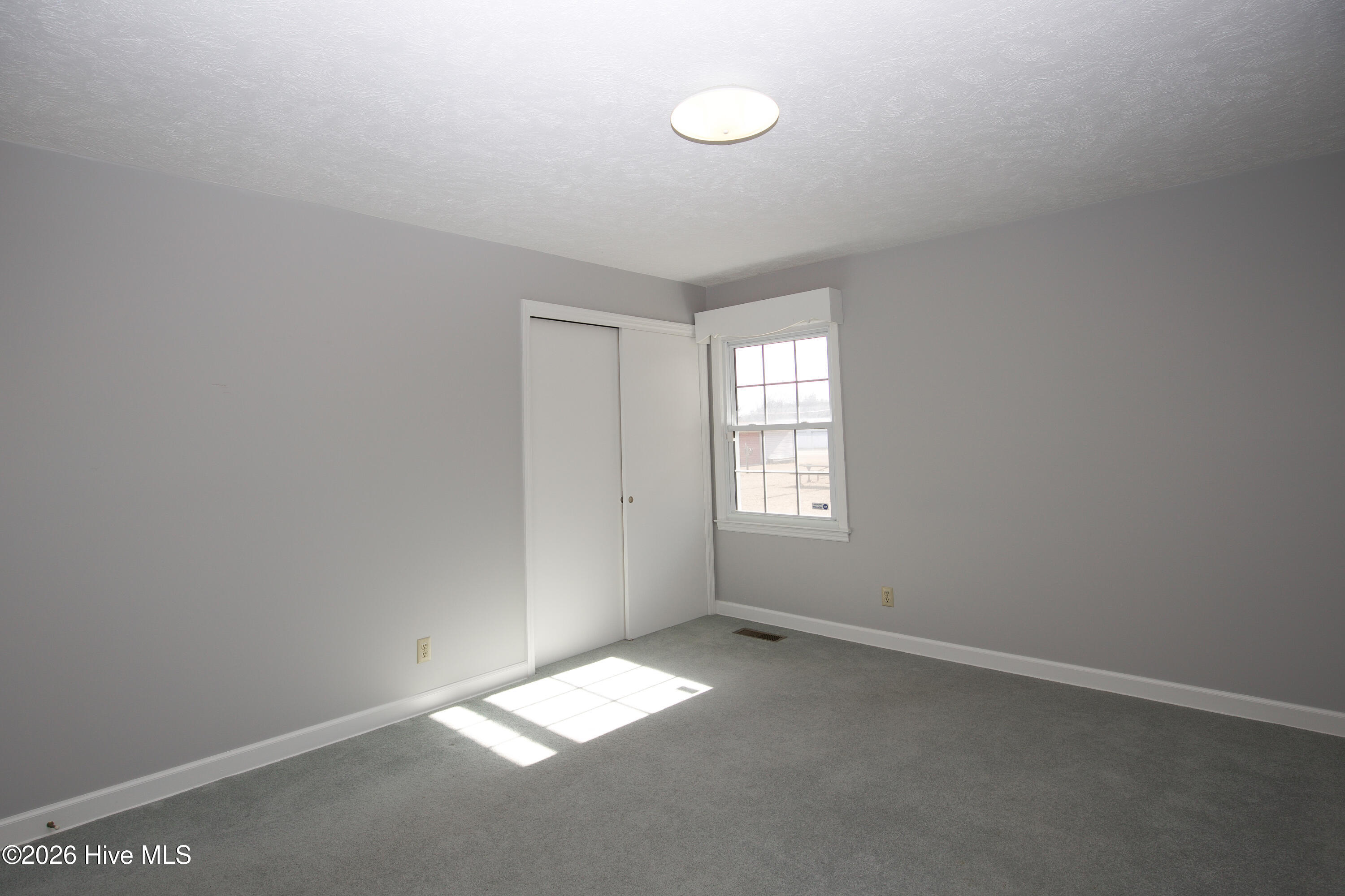 5068 Lobelia Road Vass, NC 28394 - Photo 36 of 70 Bedroom #2 is located in the southwest corner of the home and overlooks the backyard. This cozy space features soft carpeting, neutral wall color, and a generous closet. Whether used as a guest room, home office, or nursery, it offers comfort and flexibility.