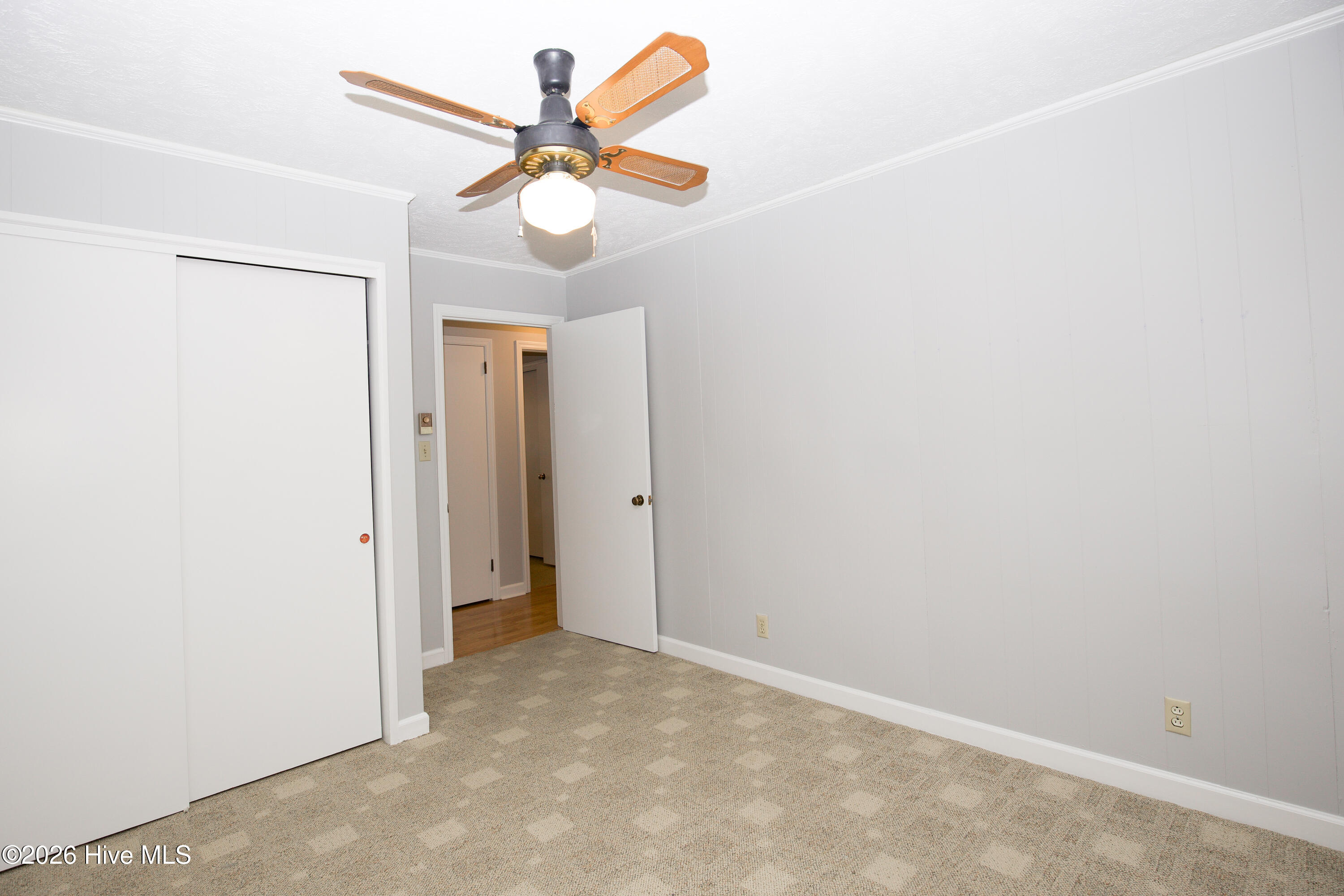 5068 Lobelia Road Vass, NC 28394 - Photo 42 of 70 Bedroom #3 shown from the doorway, offering a clear look at the neutral palette and generous layout. Features include a lighted ceiling fan, dual-door closet, and convenient hallway access. Perfect for a guest room, home office, or personal retreat.