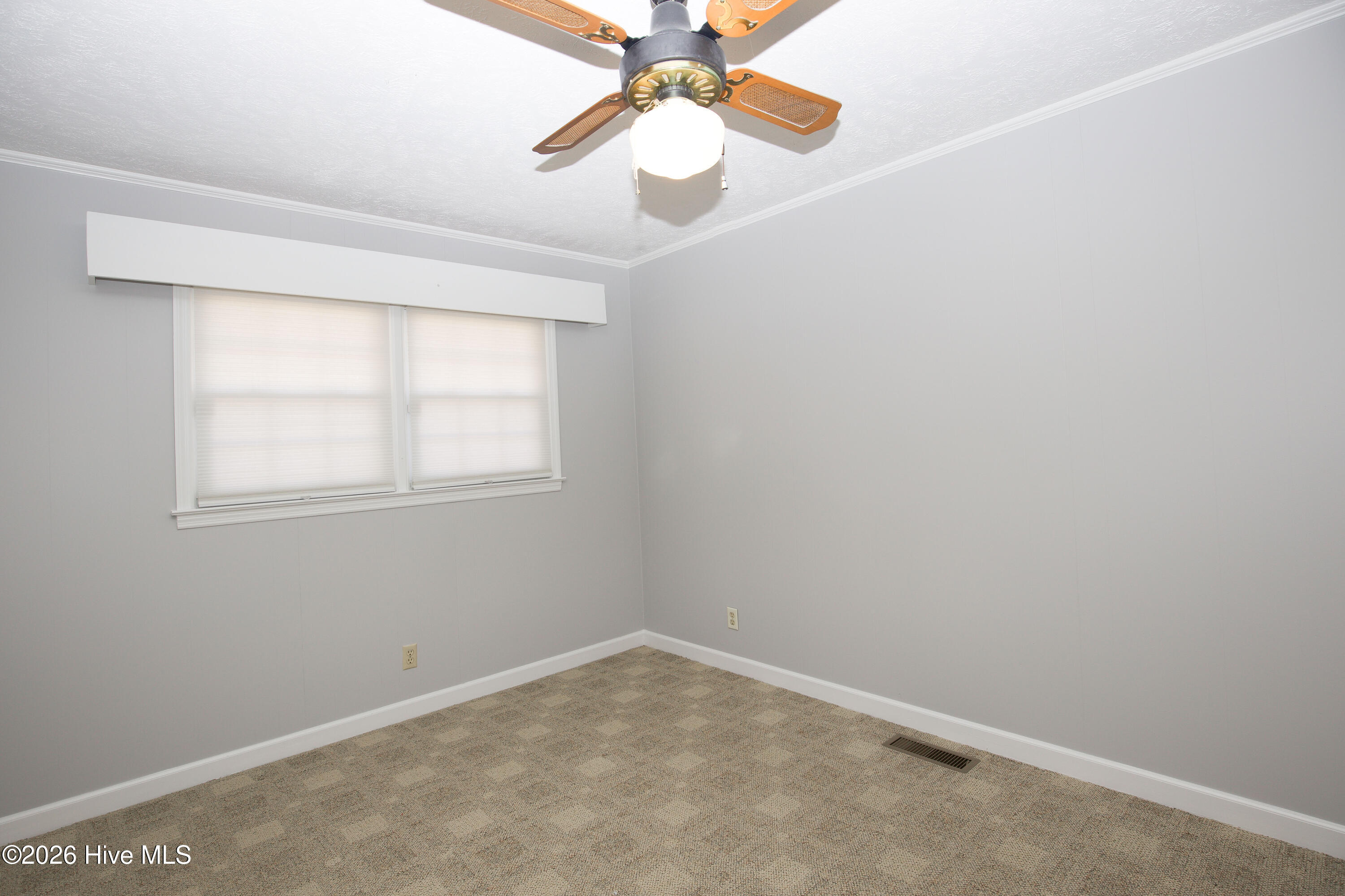 5068 Lobelia Road Vass, NC 28394 - Photo 44 of 70 Bedroom #3 featuring classic ceiling fan and twin windows with pleated shades. The soft gray palette and neutral carpet make this a flexible space for guests, a home office, or a cozy bedroom retreat.