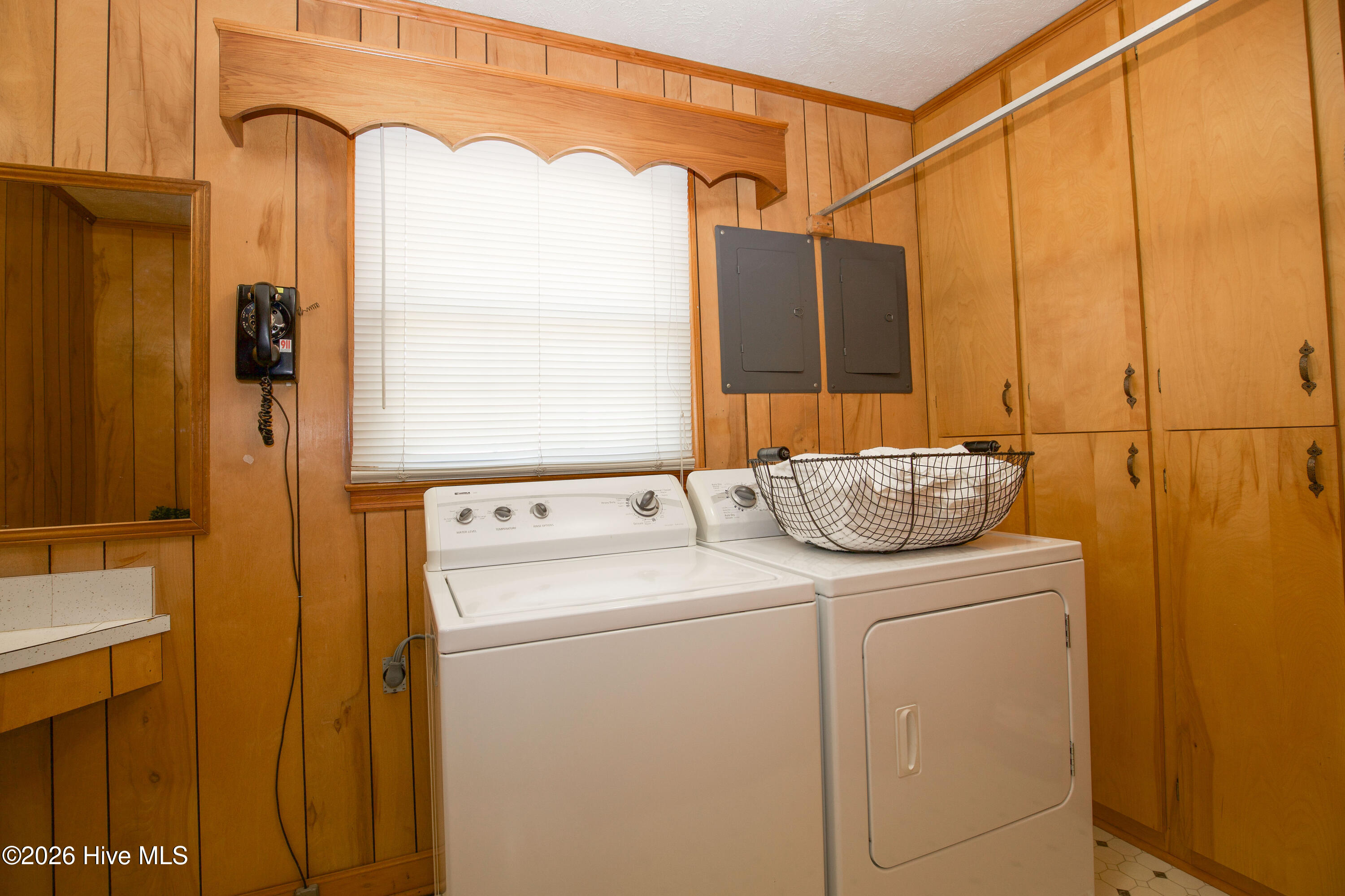 5068 Lobelia Road Vass, NC 28394 - Photo 51 of 70 Generous built-in cabinetry provides ample storage in the laundry room, alongside washer/dryer and a convenient hanging rod for drying clothes.