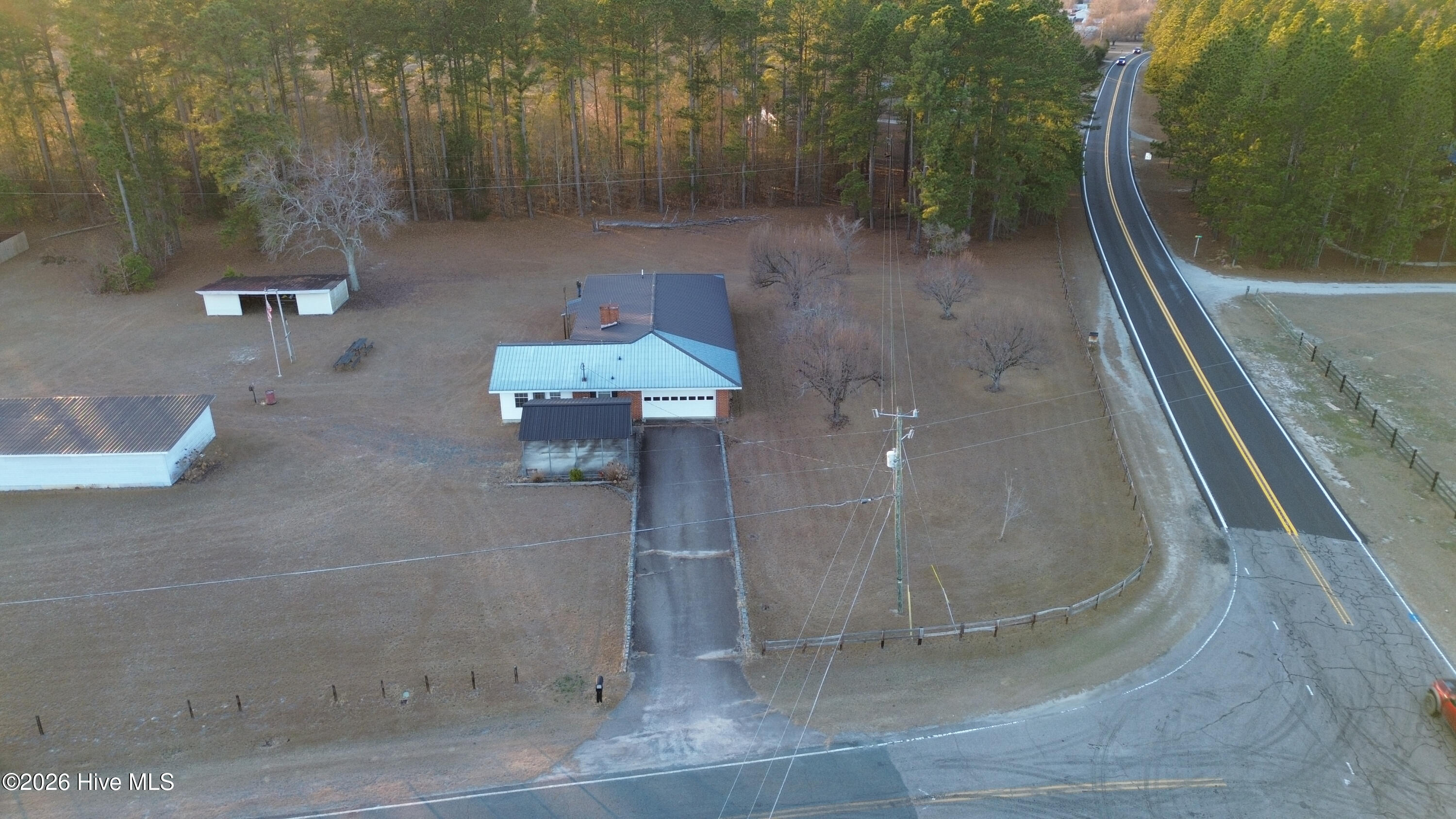 5068 Lobelia Road Vass, NC 28394 - Photo 67 of 70 Aerial view of the property at 5068 Lobelia Rd, clearly showing its position on a spacious corner lot. The driveway is seen connecting to Wright Rd, with Lobelia Rd running along the front of the property. The home, outbuildings, and tree-lined backdrop are all visible, emphasizing the lot’s layout and access.