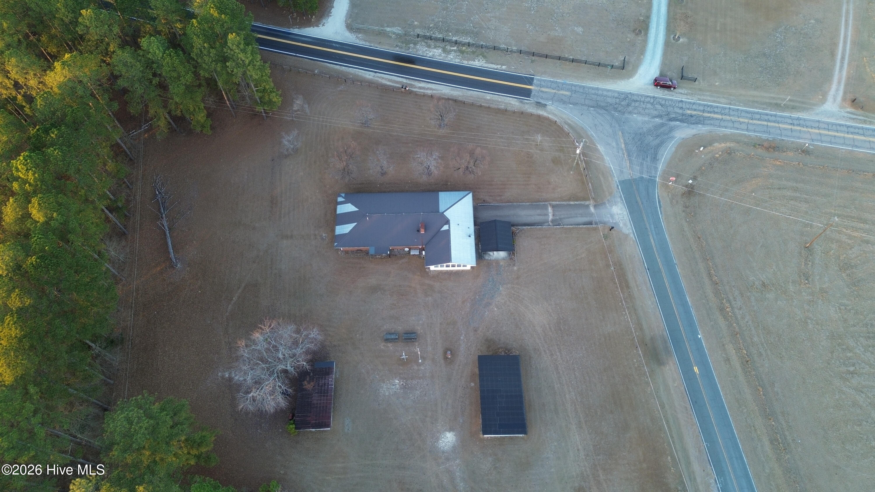 5068 Lobelia Road Vass, NC 28394 - Photo 68 of 70 Aerial view of the property at 5068 Lobelia Rd, clearly showing its position on a spacious corner lot. The driveway is seen connecting to Wright Rd, with Lobelia Rd running along the front of the property. The home, outbuildings, and tree-lined backdrop are all visible, emphasizing the lot’s layout and access.