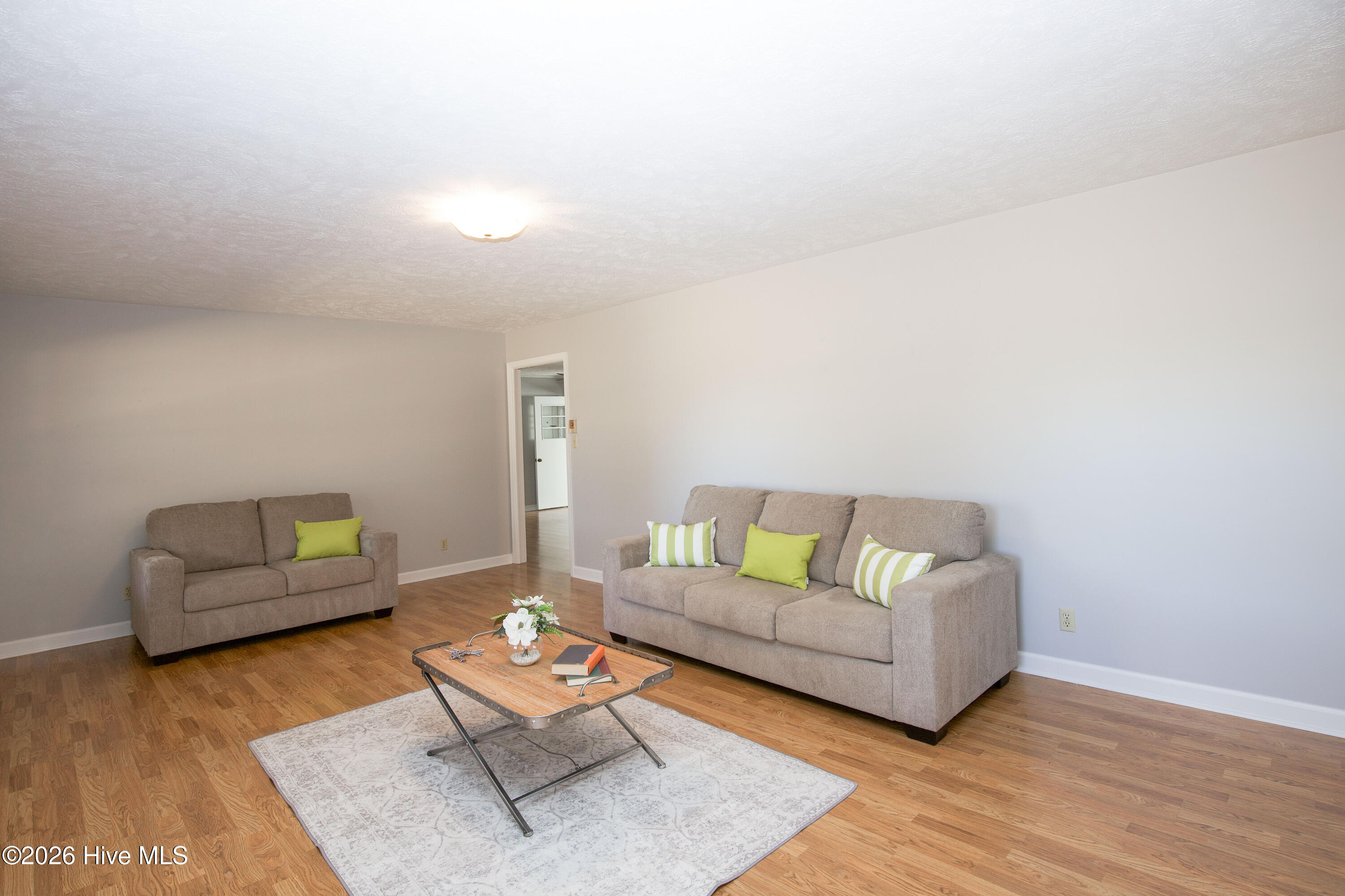 5068 Lobelia Road Vass, NC 28394 - Photo 7 of 70 This inviting living room offers a bright, comfortable space to relax or gather with guests. The large footprint provides ample room for multiple seating options, entertainment setups, or personal touches. Fresh, neutral wall colors paired with durable flooring create a timeless and easy-to-style foundation. Natural light streams in through the front-facing windows, adding warmth and brightness throughout the day. Whether you're hosting friends or enjoying a quiet evening, this versatile living area is ready for both everyday life and special occasions.