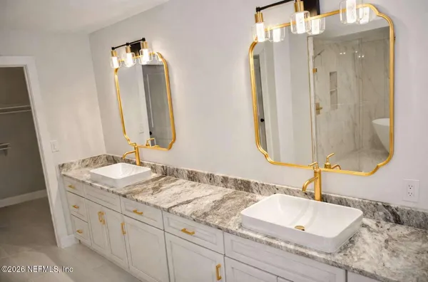 a bathroom with double vanity sinks and a mirror