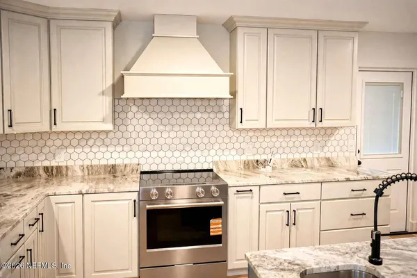 a kitchen with granite countertop white cabinets and white appliances