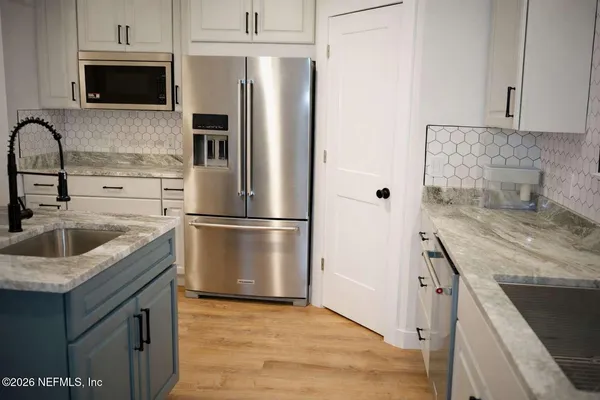 a kitchen with stainless steel appliances granite countertop a refrigerator sink and stove