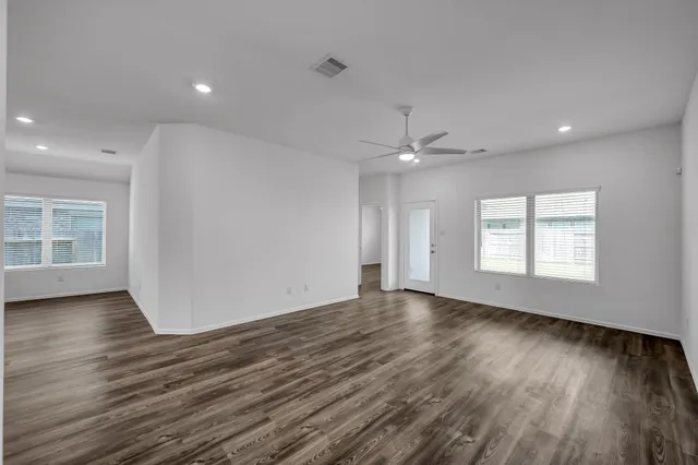 a view of empty room with wooden floor