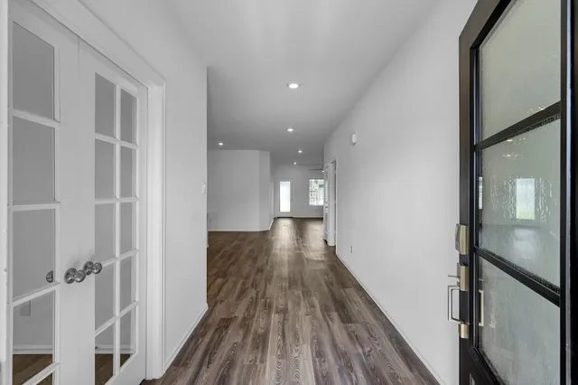 a view of a hallway with wooden floor and staircase