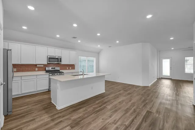 a kitchen with a sink and wooden floor