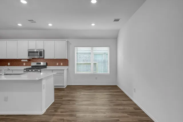 a view of kitchen with granite countertop cabinets and wooden floor