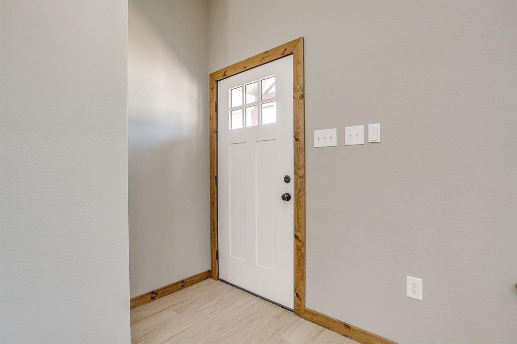 1040 Rays Way Weatherford, TX 76085 - Photo 9 of 20 White door with upper window panes, wood-finish trim, and light wood-finish flooring