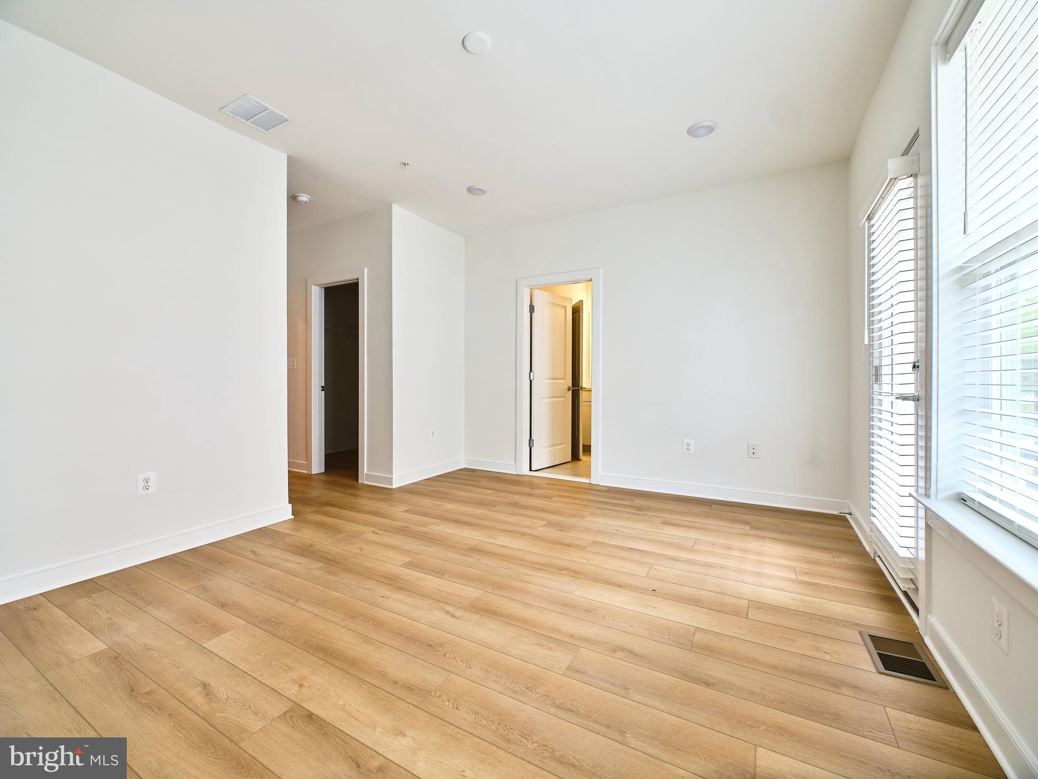 16076 Frederick Road Rockville, MD 20850 - Photo 13 of 30 a view of an empty room with wooden floor and a window