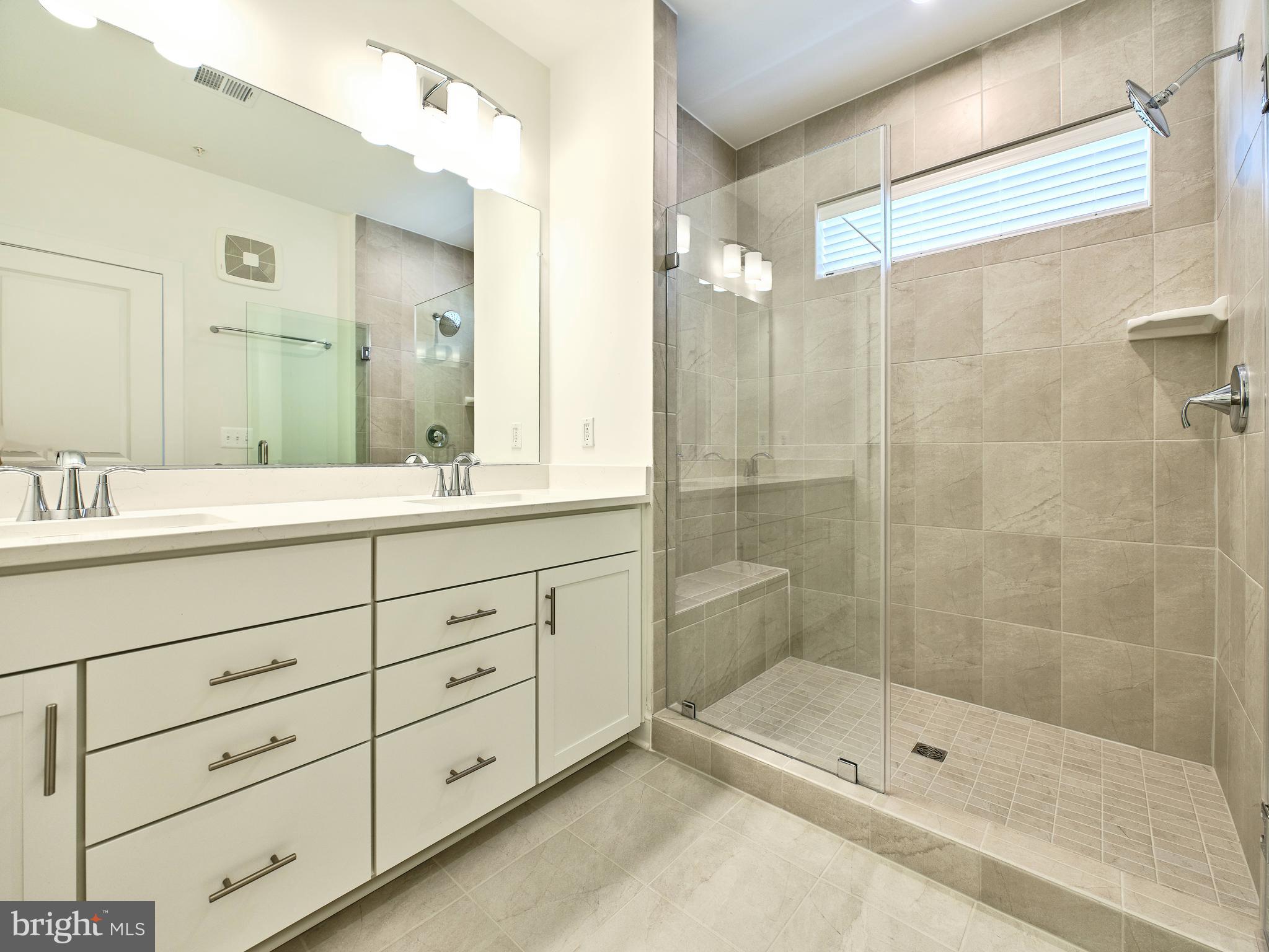16076 Frederick Road Rockville, MD 20850 - Photo 16 of 30 a bathroom with a shower tub double vanity and a shower