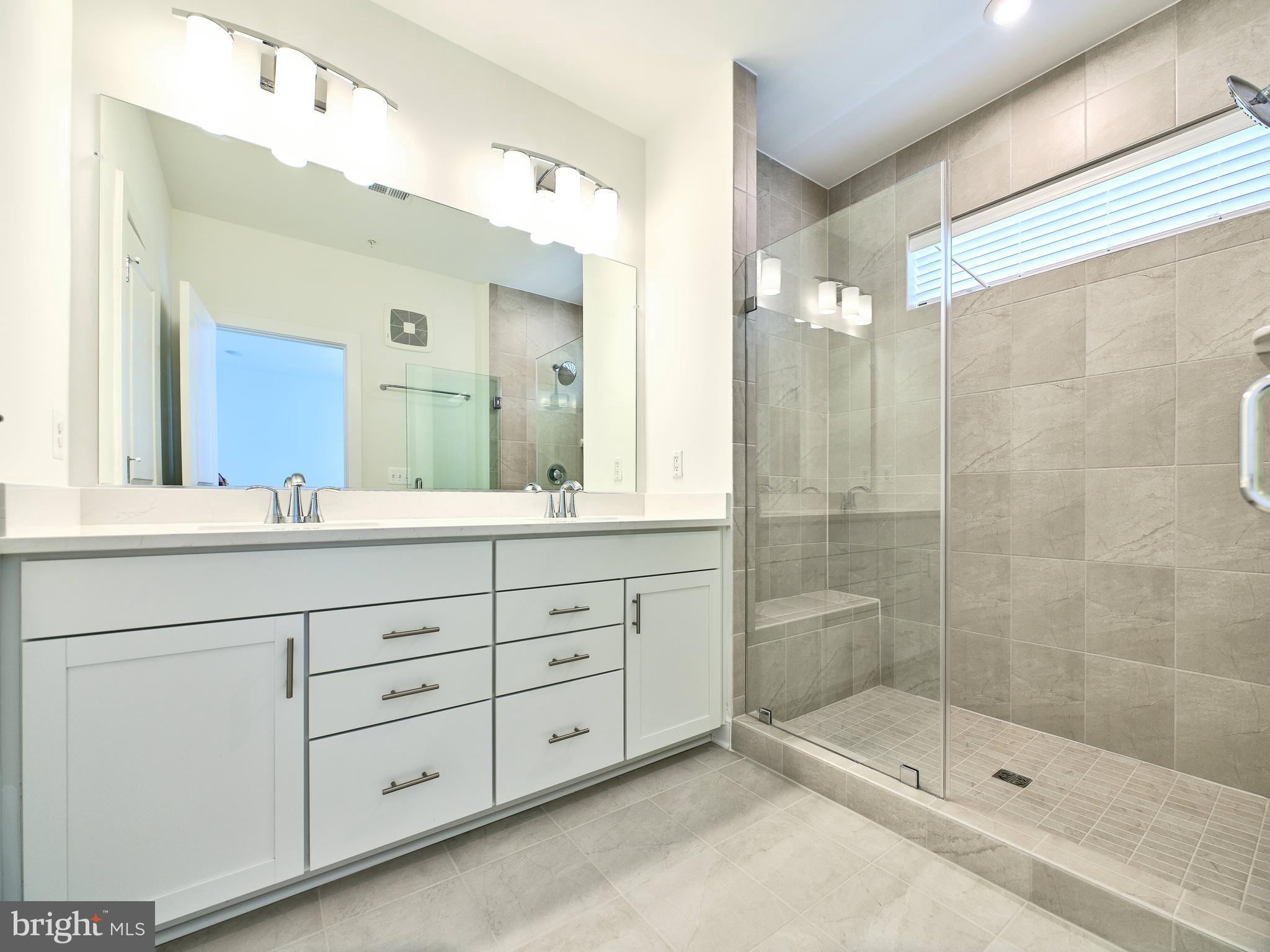 16076 Frederick Road Rockville, MD 20850 - Photo 17 of 30 a bathroom with a shower sink and mirror