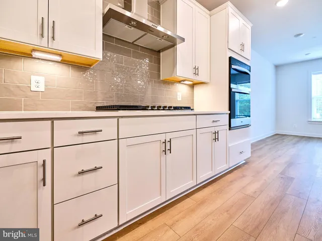 a kitchen with white cabinets and white appliances