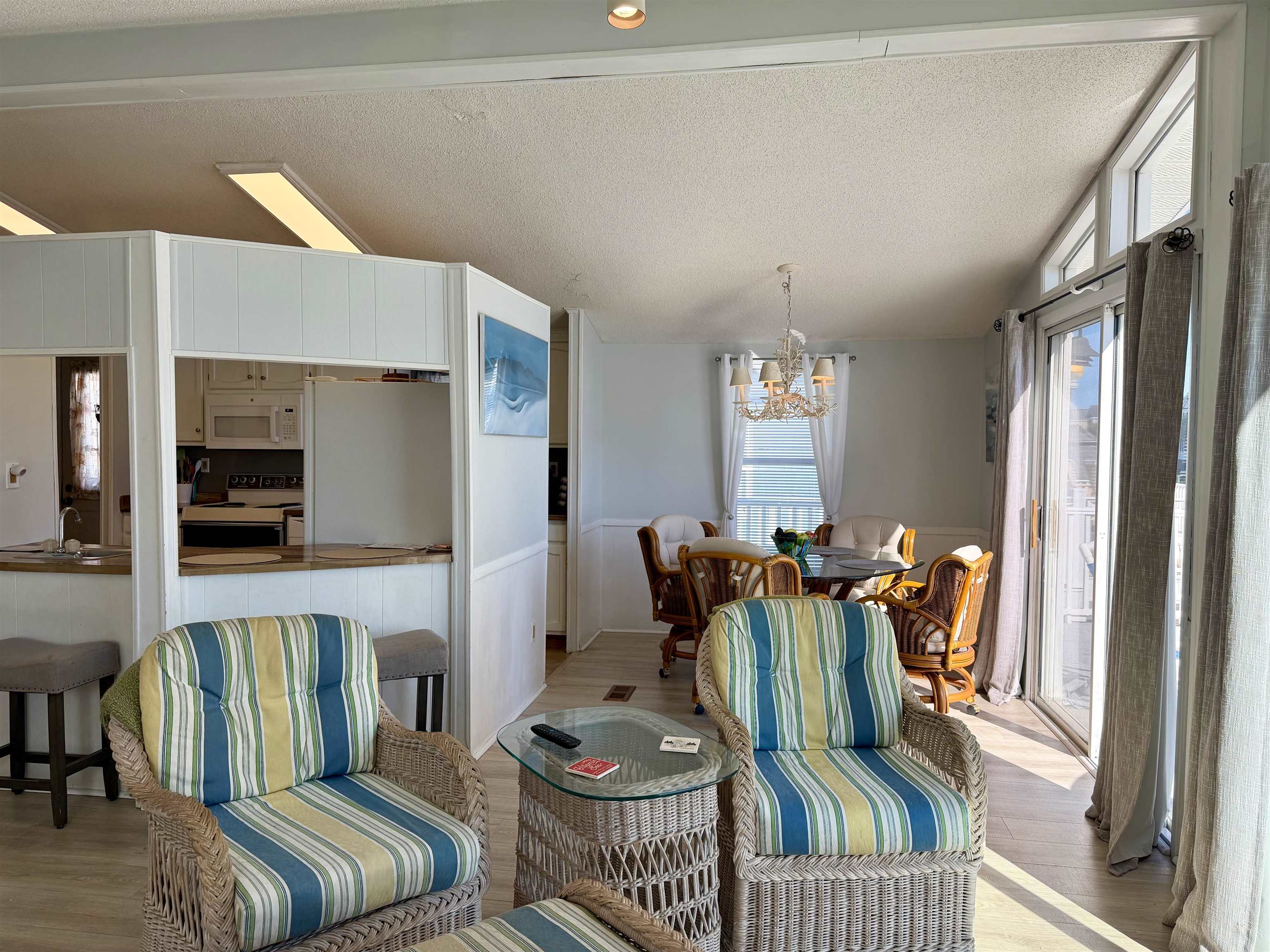 1980 Lark Surfside Beach, SC 29575 - Photo 11 of 30 Dining room with a chandelier, a wainscoted wall, a textured ceiling, vaulted ceiling, and light wood-style floors