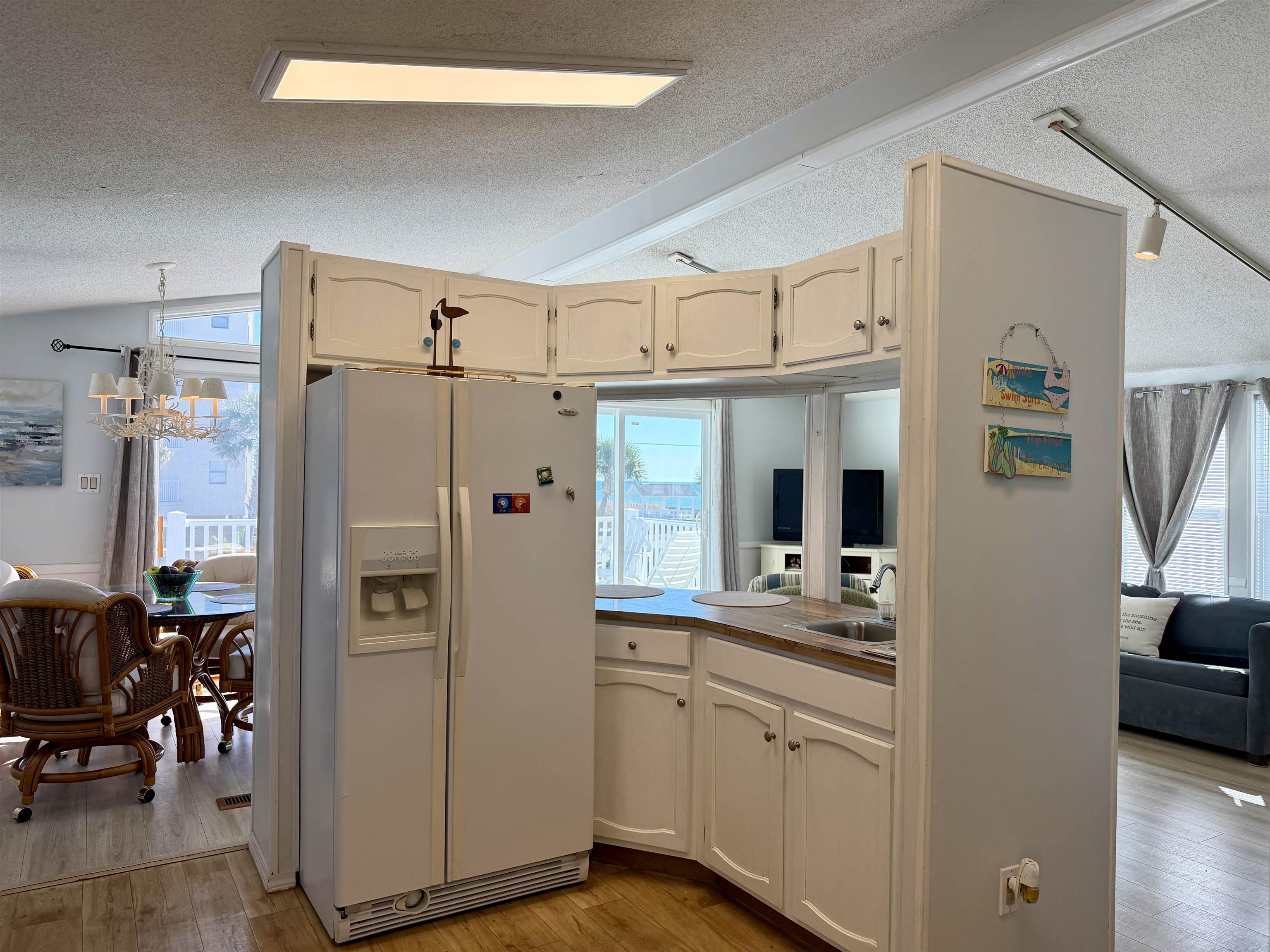 1980 Lark Surfside Beach, SC 29575 - Photo 4 of 30 Kitchen with white fridge with ice dispenser, a textured ceiling, lofted ceiling, light wood-type flooring, and healthy amount of natural light