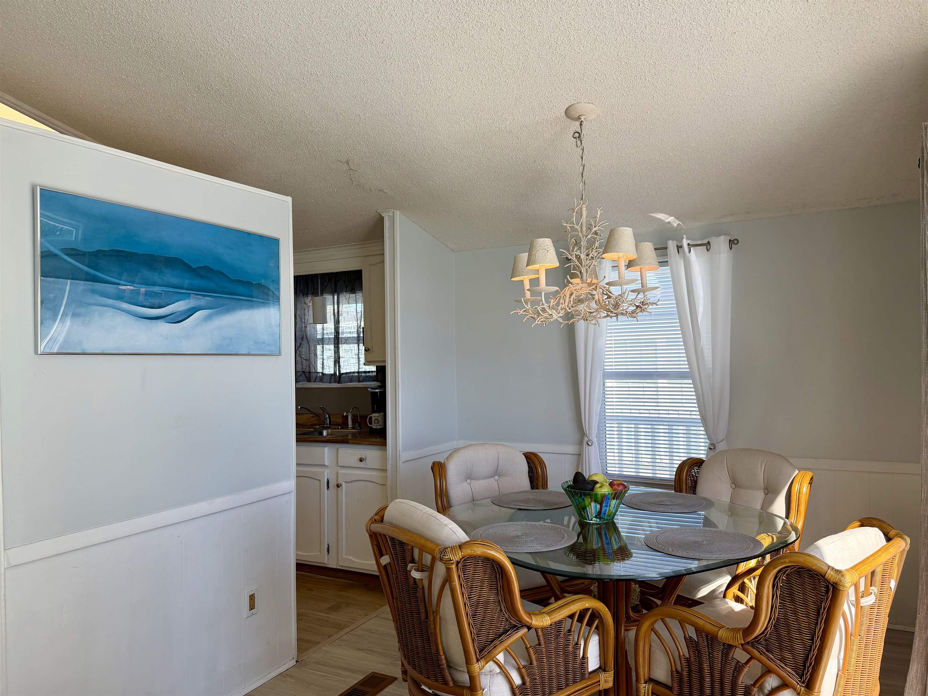 1980 Lark Surfside Beach, SC 29575 - Photo 6 of 30 Dining space with a wainscoted wall, wood finished floors, a textured ceiling, a chandelier, and a decorative wall
