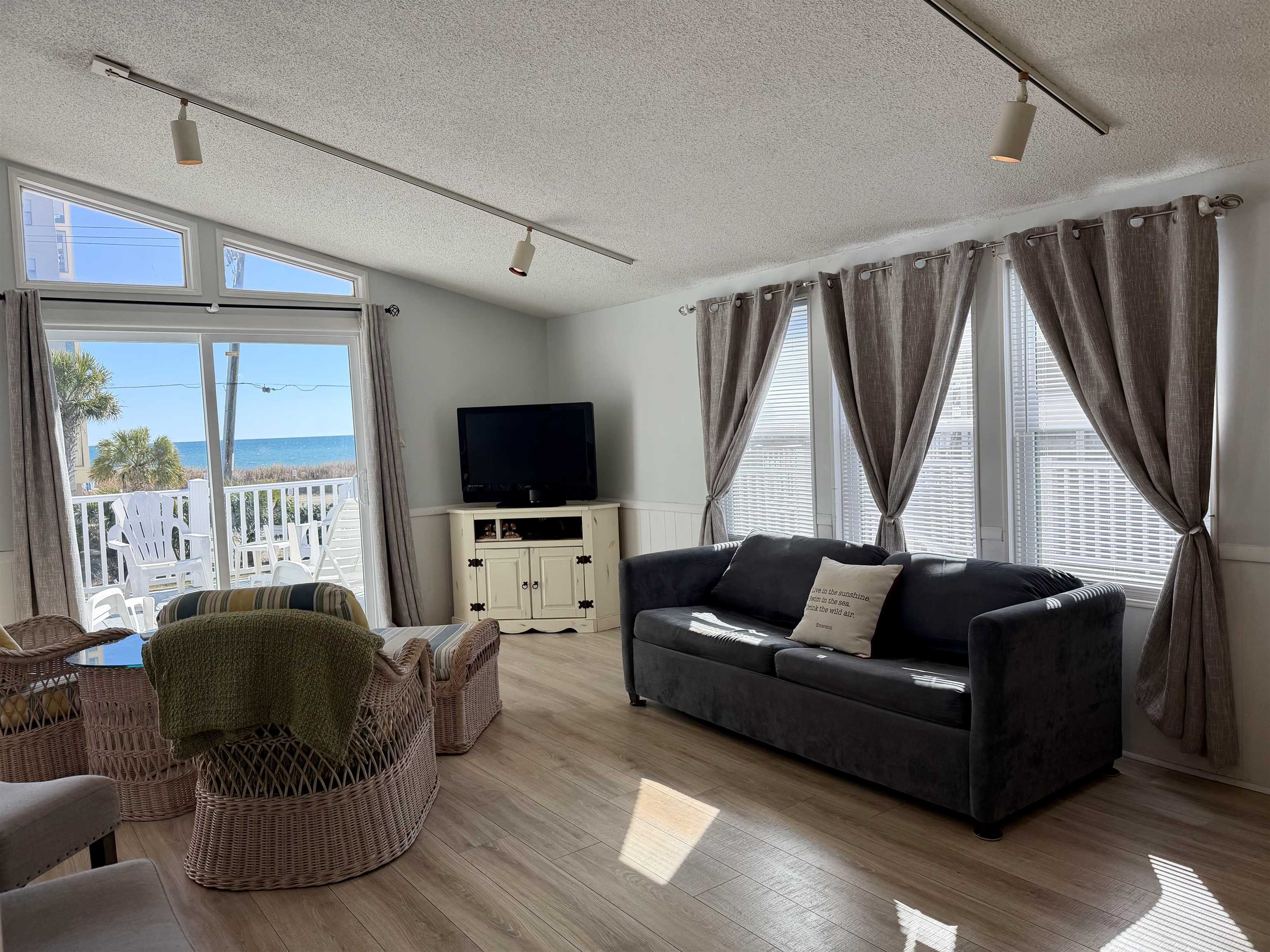 1980 Lark Surfside Beach, SC 29575 - Photo 9 of 30 Living room with rail lighting, a textured ceiling, lofted ceiling, wood finished floors, and wainscoting