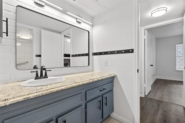 a bathroom with a granite countertop sink and a mirror
