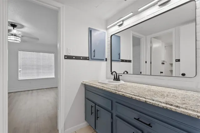 a bathroom with a granite countertop sink and a mirror