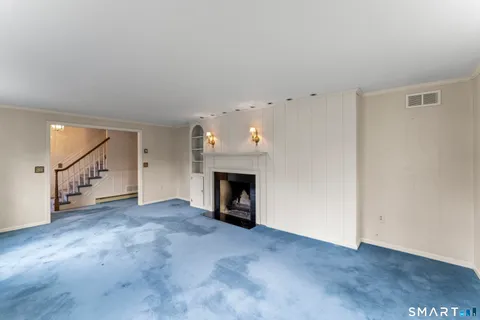a view of an empty room with fireplace and a window