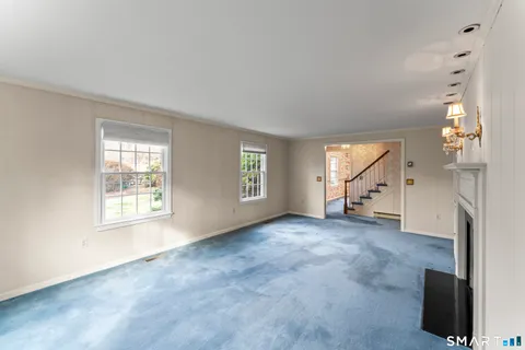 an empty room with windows and fireplace